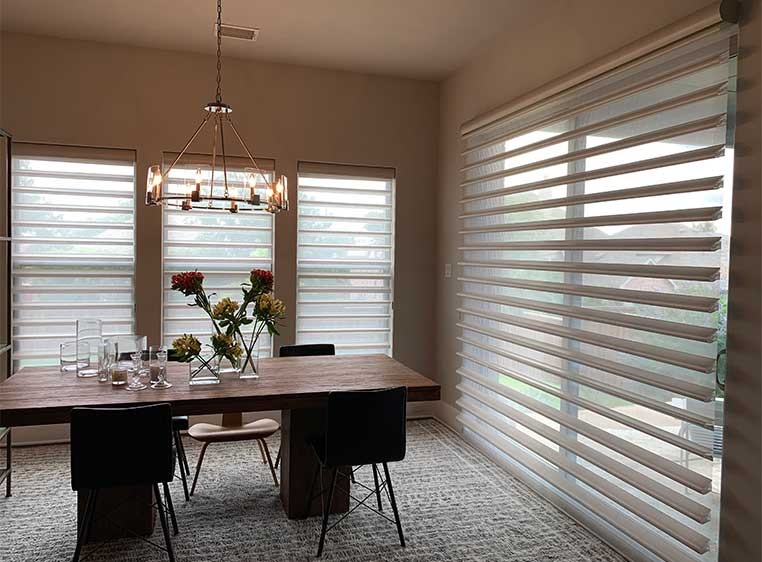 A modern-rustic dining room showcasing Hunter Douglas Pirouette shades